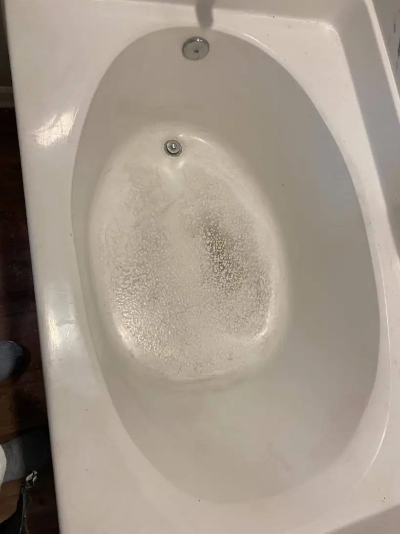 Garden tub with a worn, pitted finish on the bottom.